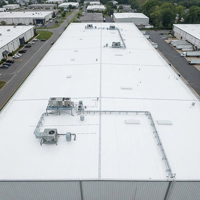 Finished roof — seamless white TPO system across the warehouse with HVAC curb flashing.