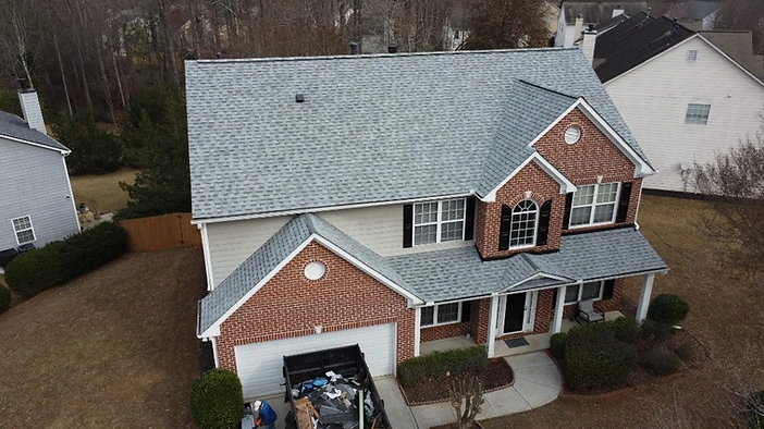 Completed roof — charcoal architectural shingles installed across all roof planes with clean ridges and flashing.