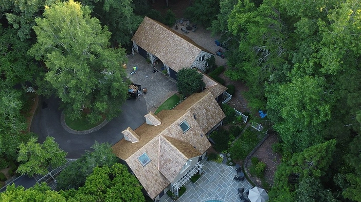 Finished roof — unified cedar shake system across the main residence and detached garage.