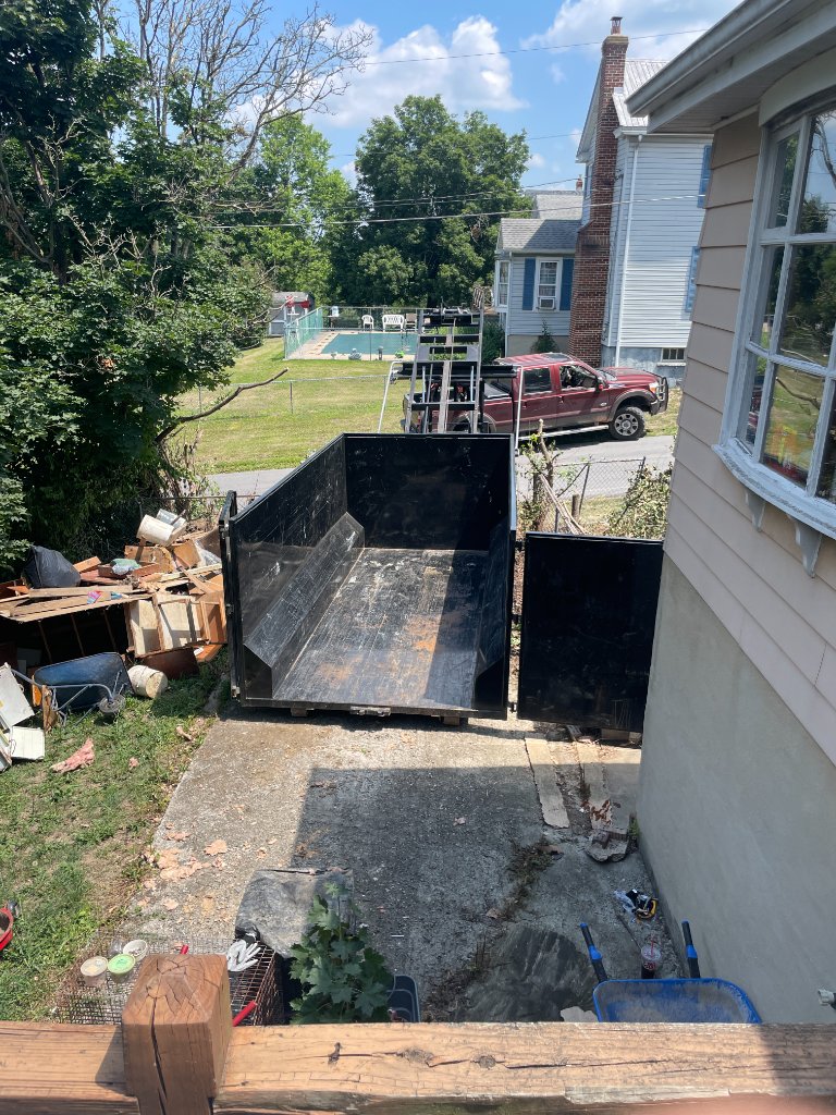 ZK dumpster on concrete pad at residential home with pool