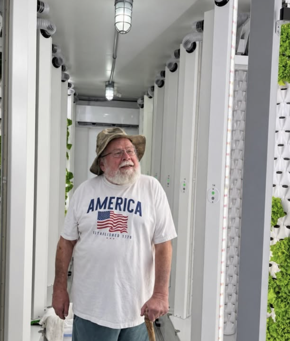 Visitor standing in the aisle of the hydroponic container farm