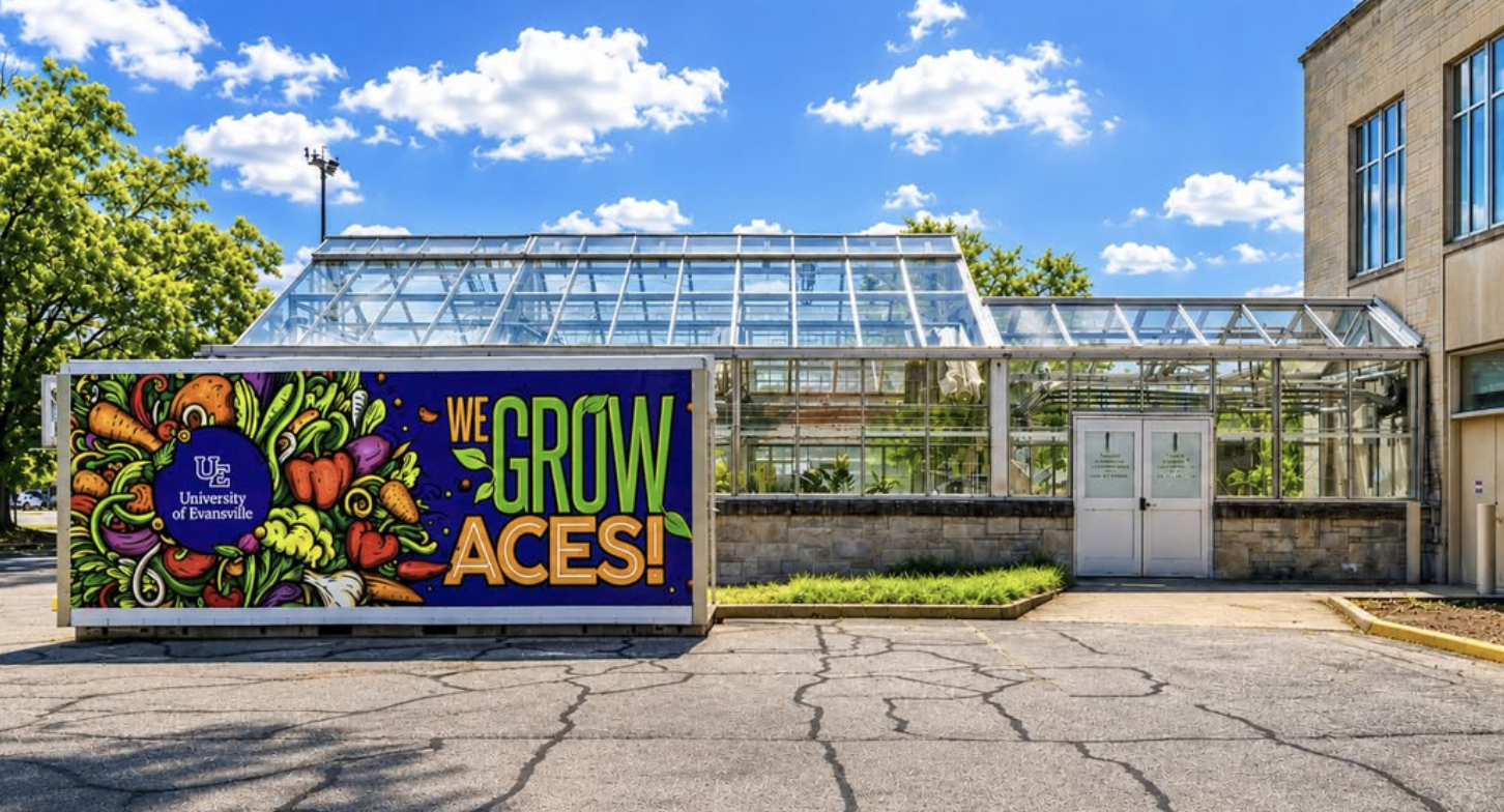 We Grow Aces shipping container farm beside a greenhouse