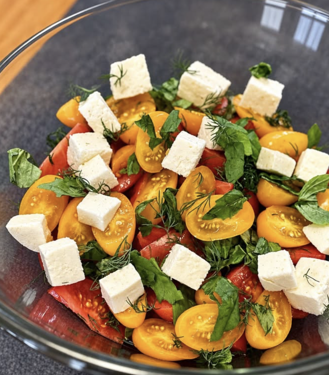Fresh salad with yellow tomatoes, feta, and herbs