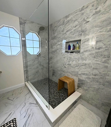Walk-in shower with marble tile and frameless glass