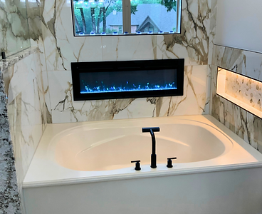 Primary bathroom with soaking tub, marble walls and fireplace