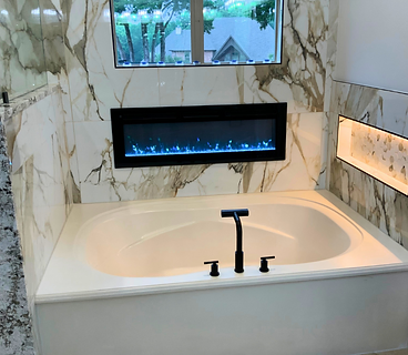 Primary bathroom with soaking tub, marble walls and fireplace