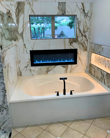 Primary bathroom with soaking tub, marble walls and fireplace