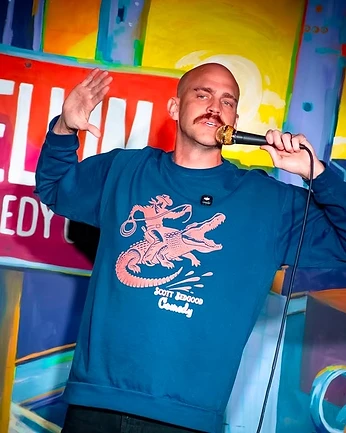 Scott Bedgood performing on stage at Helium Comedy Club