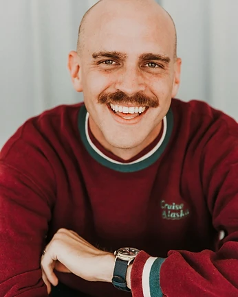 Scott Bedgood laughing headshot in maroon Cruise Alaska sweatshirt