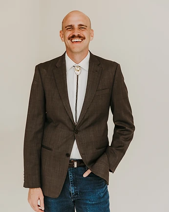 Scott Bedgood in brown blazer with bolo tie, laughing