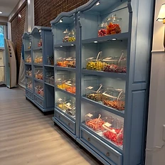 Sweet Tide blue candy display shelving along brick wall