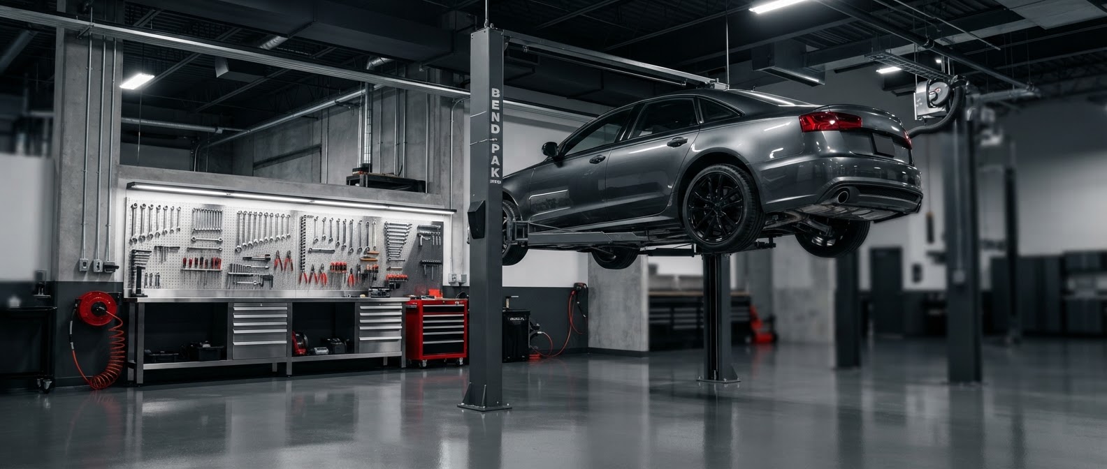 Clean auto repair shop bay with vehicle lifted and professional tools visible