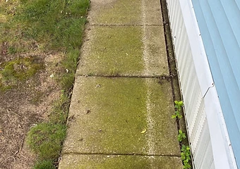 Concrete walkway alongside a light blue mobile home