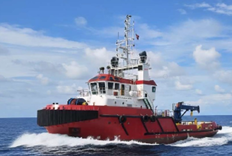 Red and white offshore support vessel creating a wake