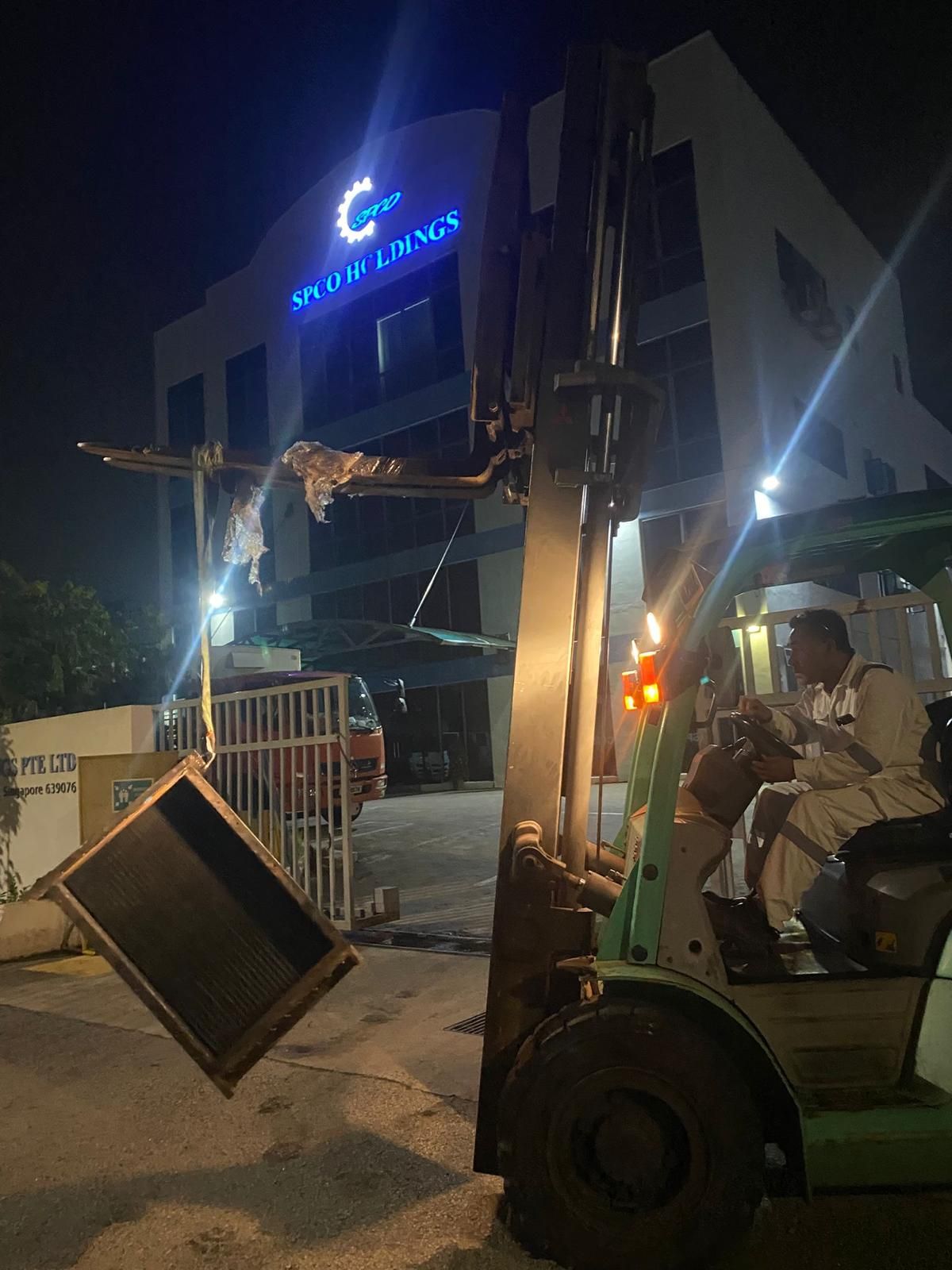 Air cooler core being handled by forklift during night workshop logistics
