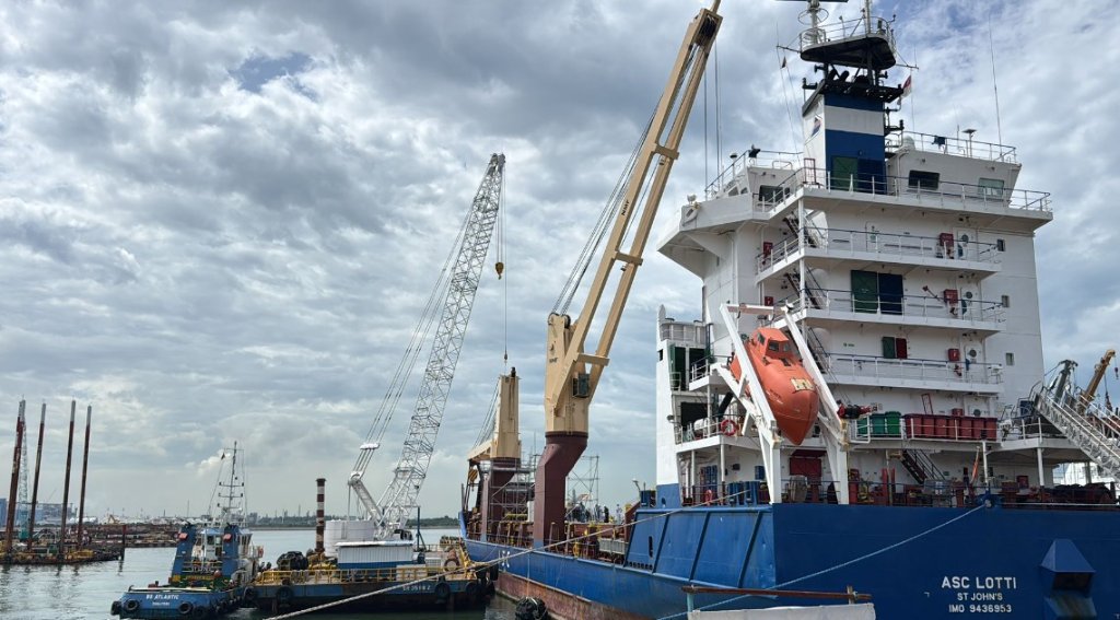 Cargo vessel ASC Lotti docked at harbour with tugboat alongside