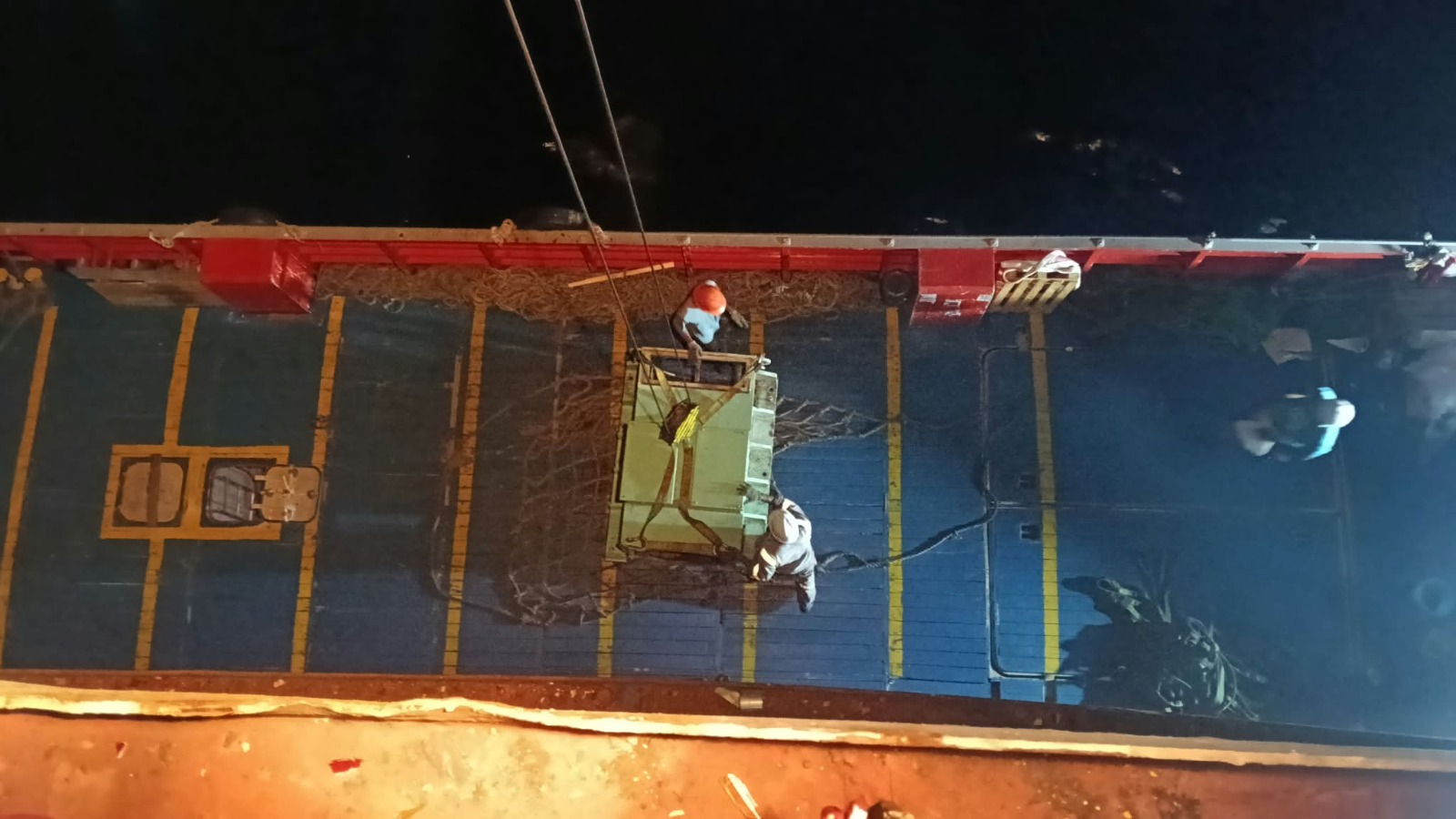 Pale-green machinery unit suspended above the deck during crane recertification lifting operations