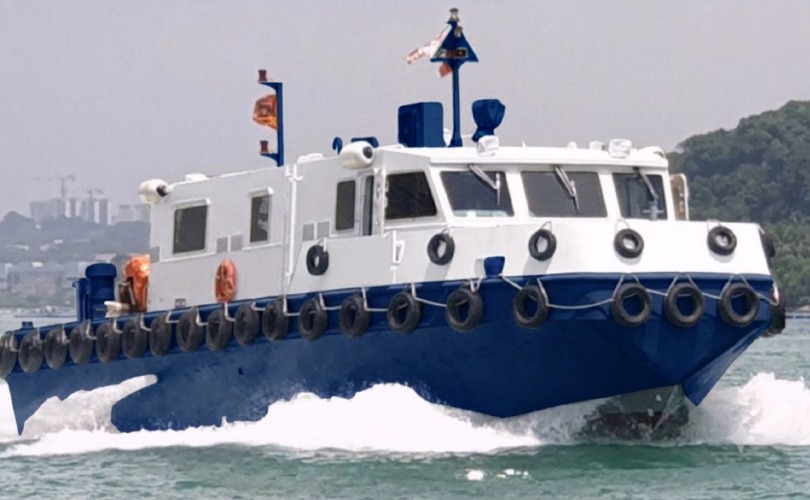White and navy blue utility vessel navigating through water