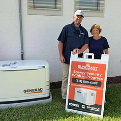 Happy Suncoast Power Solutions customer with their newly installed home generator yard sign