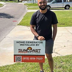 Happy Suncoast Power Solutions customer with their newly installed home generator yard sign