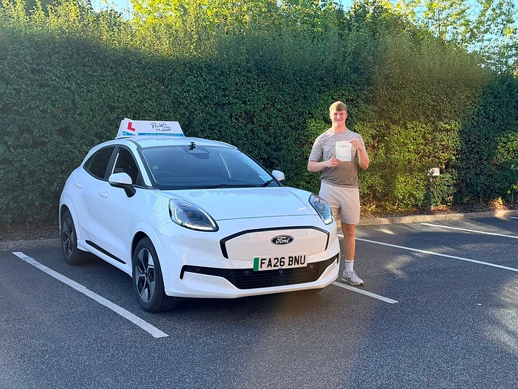 Student celebrating a driving test pass with the PassWith Ford Puma Gen-E electric car in Leeds