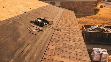 A residential roof mid-replacement with new architectural shingles over fresh underlayment