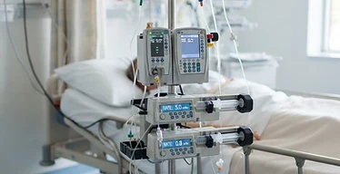 IQX Infusion Platform — Volumetric infusion pumps and syringe pumps mounted on an IV pole beside a patient bed