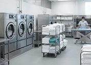 Patient Gowns (Pack) — Hospital laundry facility with industrial washing machines and clean linen carts