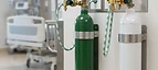 Oxygen Concentrator — Medical gas cylinders with regulators and wall outlet panels in a hospital