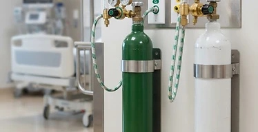 Gas Cylinder Storage Rack — Medical gas cylinders with regulators and wall outlet panels in a hospital