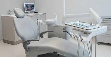 Dental Implant Motor — Dental treatment chair unit with overhead operating light in a modern dental clinic