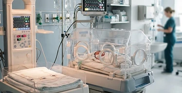 Neonatal Incubator — Neonatal incubator and radiant warmer with neonatal monitor in a neonatal intensive care unit
