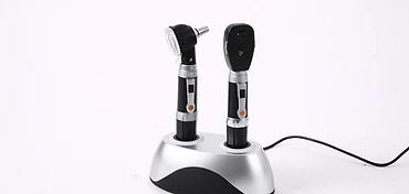 Rechargeable otoscope and ophthalmoscope desk set with two instrument handles docked in a silver-top charging station
