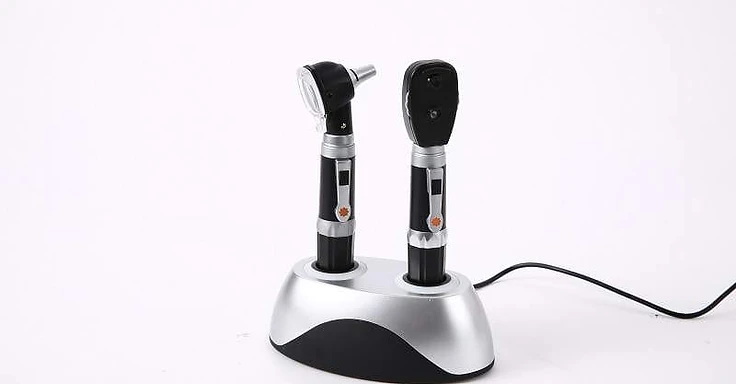Rechargeable otoscope and ophthalmoscope desk set with two instrument handles docked in a silver-top charging station