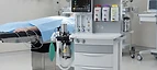 Servo-u Mechanical Ventilator — Anaesthesia machine with ventilator and vaporisers beside an operating table