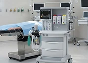 Servo-u Mechanical Ventilator — Anaesthesia machine with ventilator and vaporisers beside an operating table