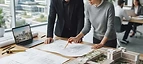 Hospital Master Plan — Architects reviewing hospital master plan blueprints and a healthcare campus scale model