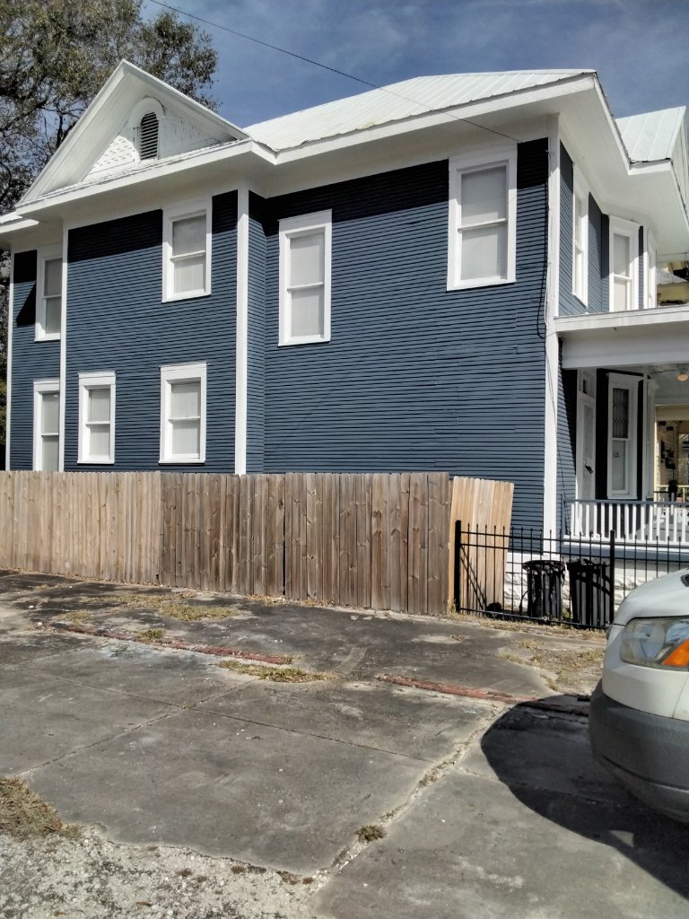 After: freshly refinished blue home exterior with crisp white trim