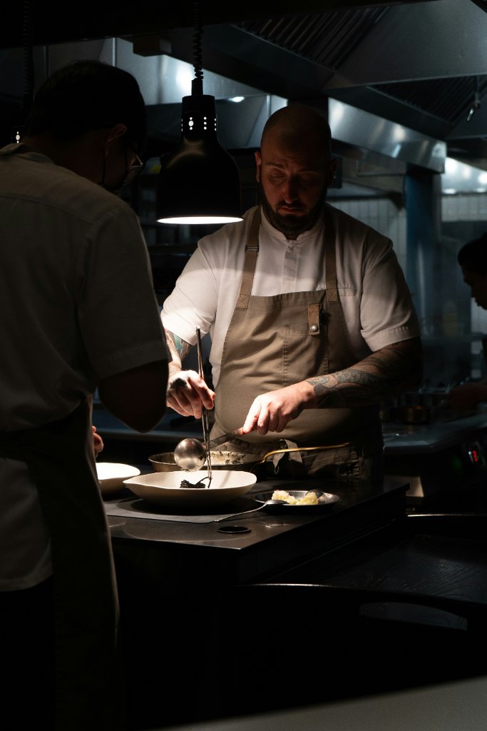 Chef plating a dish in a professional kitchen