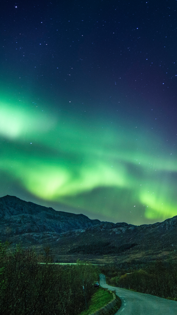 Northern lights over a mountain road in the Nordics