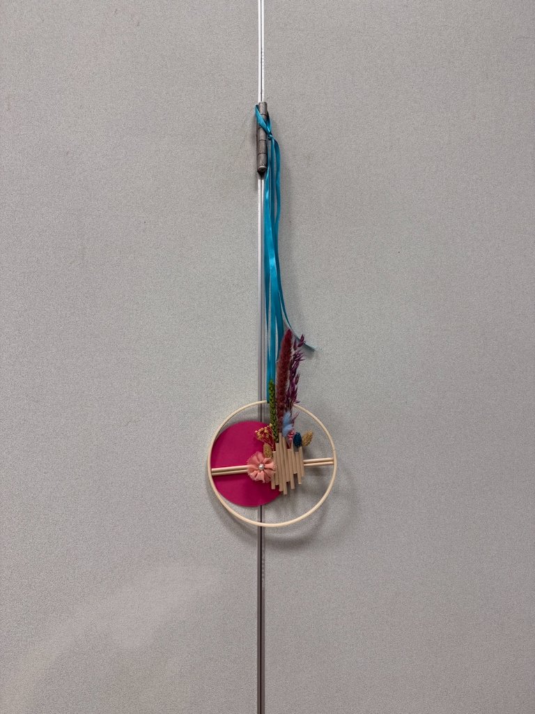 Suspension florale en cercle de bois avec fleurs séchées, disque fuchsia et ruban turquoise