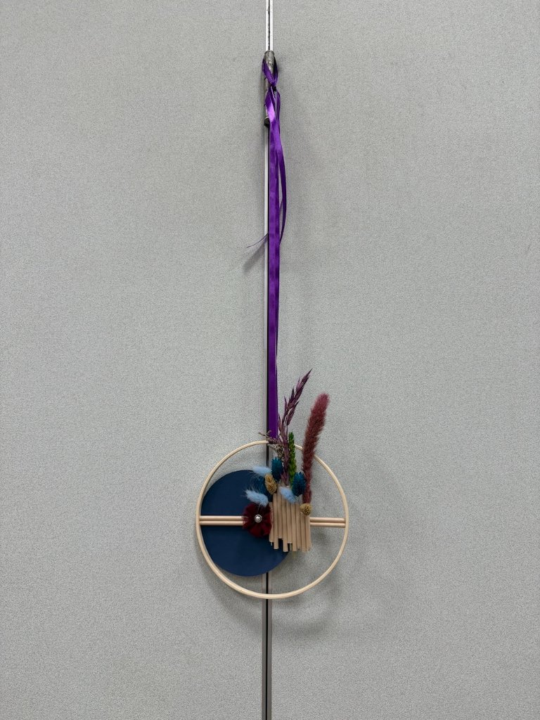 Suspension florale en cercle de bois avec fleurs séchées, disque bleu nuit et ruban violet
