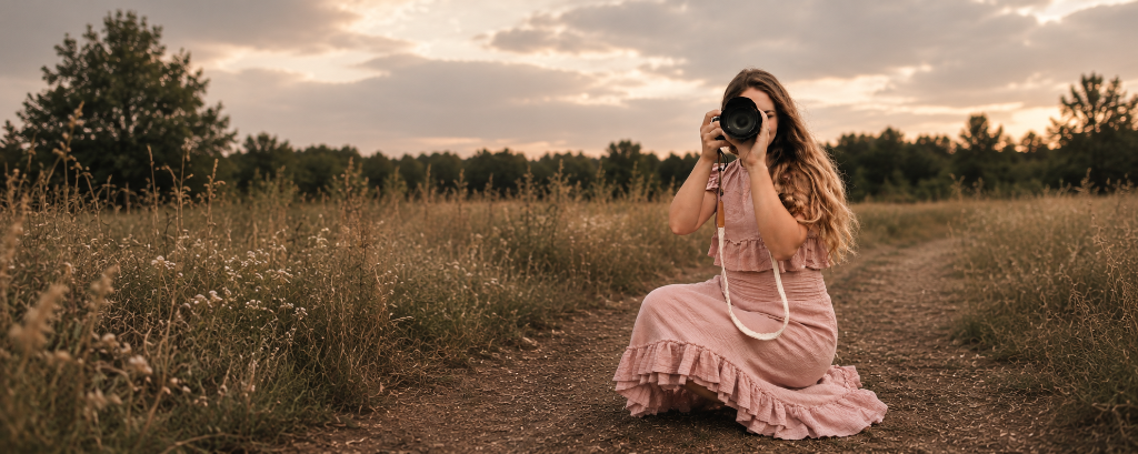 Emma-Kate Spearman photographing in a field at sunset