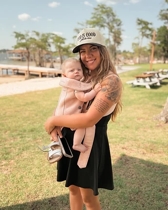 Emma wearing her GOD IS GOOD hat with her baby