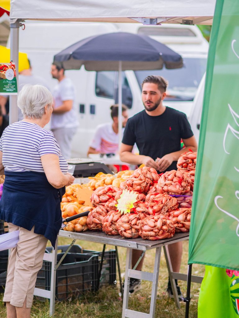 Échange entre un producteur et une visiteuse sur un stand de la Foire de Chignat à Vertaizon