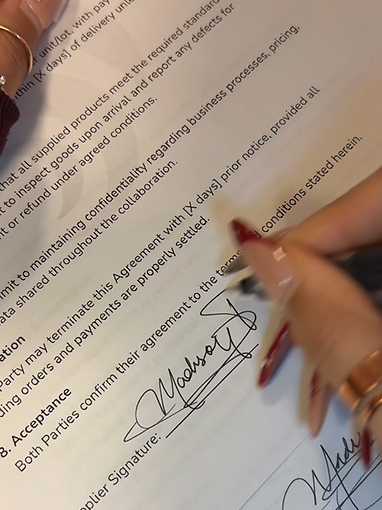 A hand signing a document with a custom signature