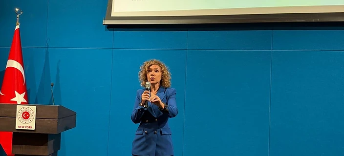 Duygu Ozen speaking on stage with a microphone
