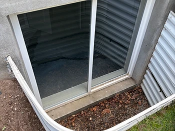 The same basement window with the hard water haze removed and clear glass after cleaning
