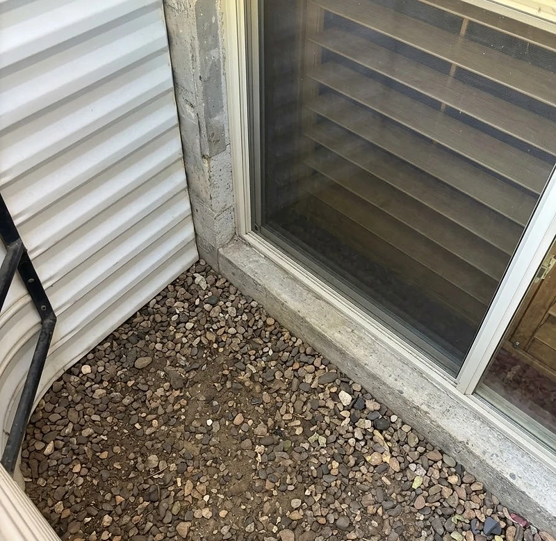 A clean, debris-free window well letting daylight into a basement window