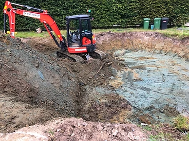 Mini excavator digging the pool excavation to depth in Surrey